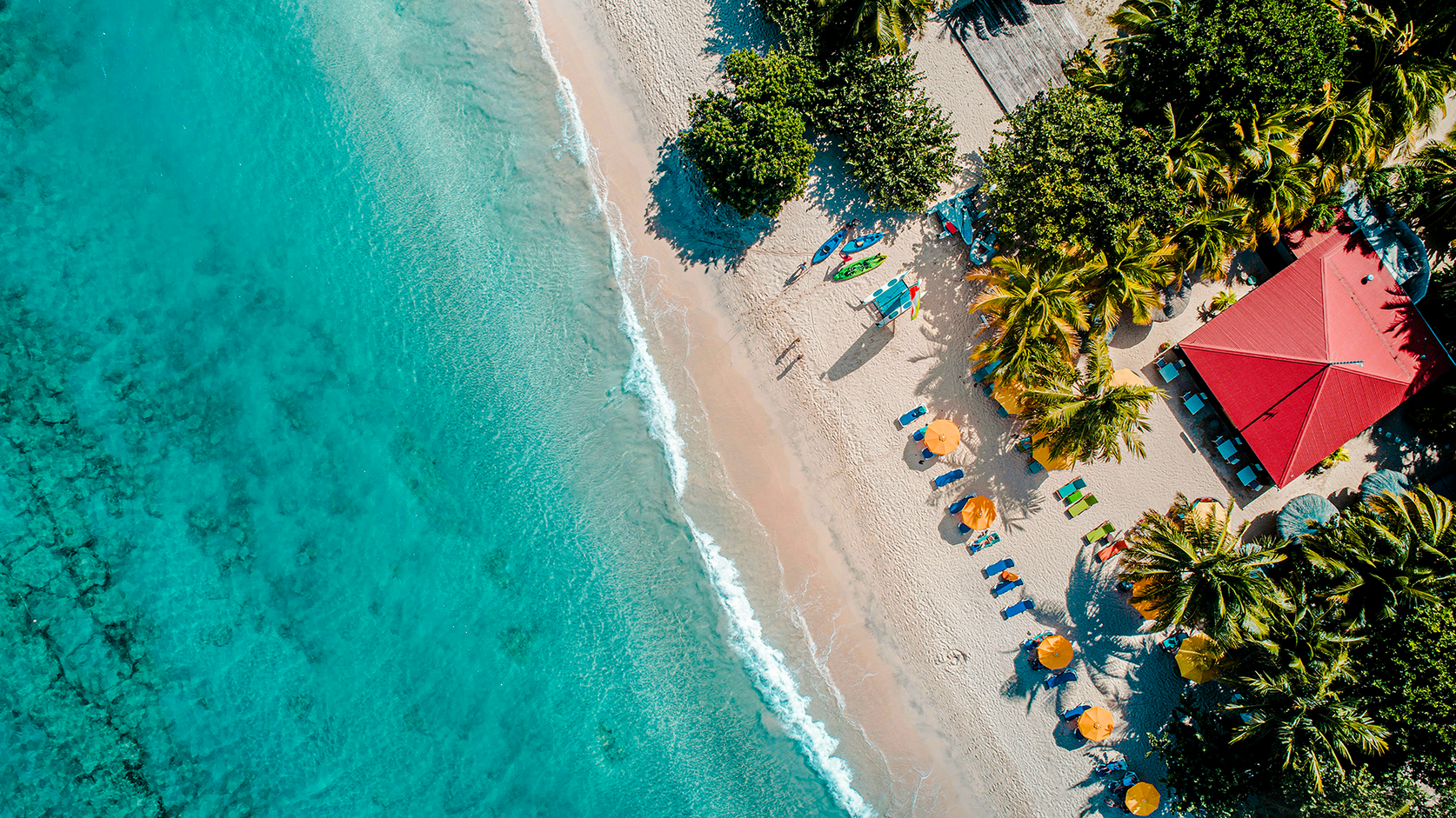 Tropischer Sandstrand mit türkisblauem Meer aus der Vogelperspektive